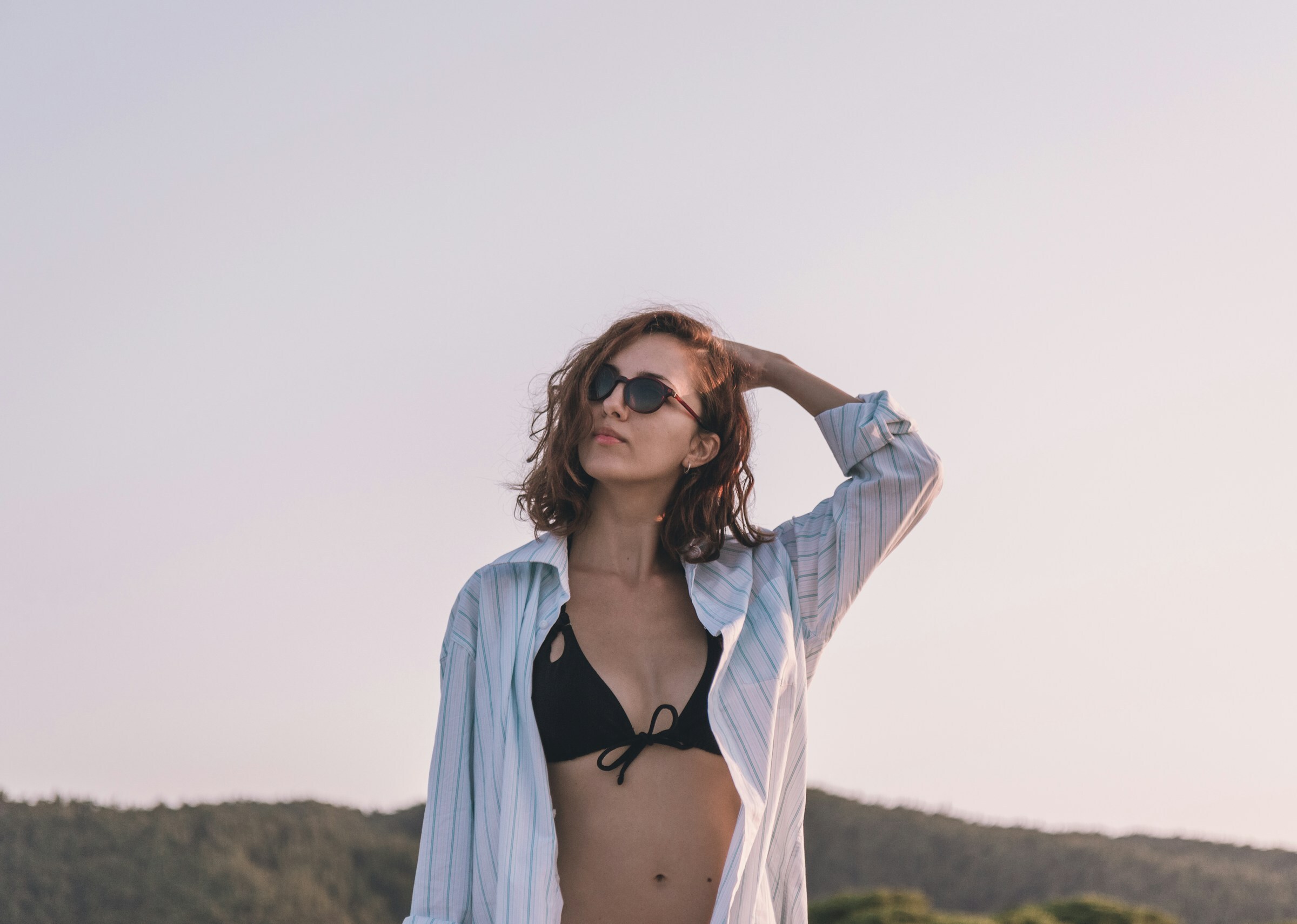 Photo by Kristijan Arsov on Unsplash | woman in bikini looking up to the sky by sunset